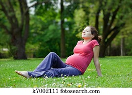 Pregnant woman relaxing in the park Pregnant woman relaxing in the park