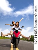 Happy young woman having summer trip on a scooter