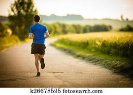 Male athlete/runner running on road 