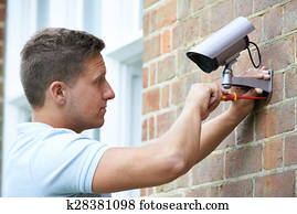 Security Consultant Fitting Security Camera To House Wall Security Consultant Fitting Security Camera To House Wall