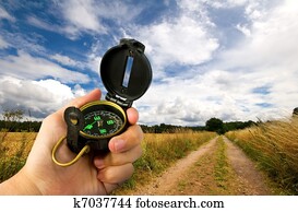 man holding compass in field