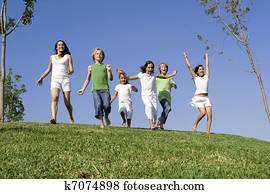group of happy kids at summer camp or school running or racing group of happy kids at summer camp or school running or racing