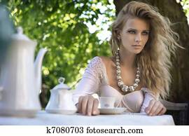 Young beauty at lunch table in garden
