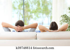 Couple relaxing on a couch at home Couple relaxing on a couch at home