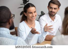 Happy woman leader coach mentor talking to employees at meeting