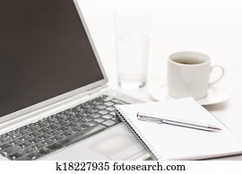 Office desk laptop with notepad and pen