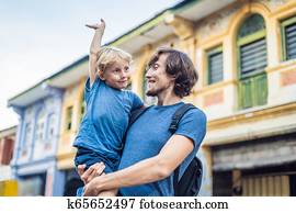 Dad and son in the background of Old houses in the Old Town of Georgetown, Penang, Malaysia