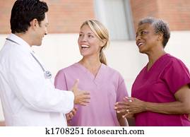 Doctor And Nurses Standing Outside A Hospital