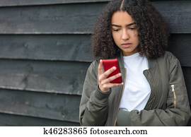 carrera mezclada, muchacha americana africana, adolescente, en, teléfono celular