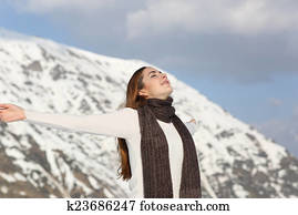 Woman breathing fresh air raising arms in winter Woman breathing fresh air raising arms in winter