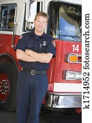Fireman standing in front of fire engine Fireman standing in front of fire engine