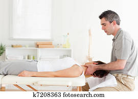 Chiropractor massaging woman's neck Chiropractor massaging woman's neck