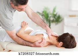 Chiropractor stretching a woman's shoulder Chiropractor stretching a woman's shoulder