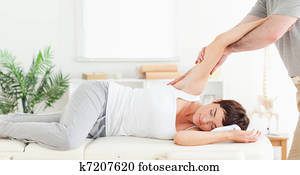 Chiropractor stretching woman's arm Chiropractor stretching woman's arm