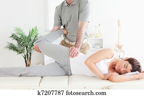 Female customer's leg stretched by chiropractor Female customer's leg stretched by chiropractor
