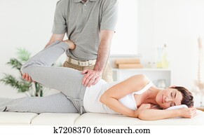 Woman's leg stretched by chiropractor Woman's leg stretched by chiropractor