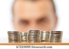 Businessman looking at piles of pennies