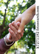 Senior and young holding hands