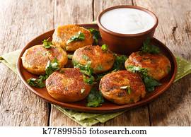 Street food of India. Potato Aloo Tikki served with yogurt closeup in a plate. horizontal Street food of India. Potato Aloo Tikki served with yogurt closeup in a plate. horizontal