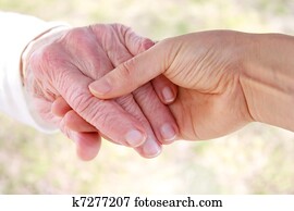 Young holding senior lady's hand Young holding senior lady's hand