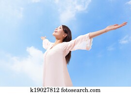 Beautiful woman breathing fresh air with raised arms