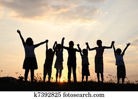 silueta, grupo, de, feliz, jogar crianças, ligado, prado, pôr do sol, verão