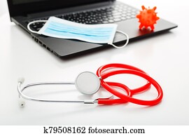 Red Stethoscope, surgical protective mask, model of coronavirus Microscope virus on laptop. Coronavirus covid-19 covid19 prevention. Medicine health care concept. Doctors workplace, doctors appointment Red Stethoscope, surgical protective mask, model of coronavirus Microscope virus on laptop. Coronavirus covid-19 covid19 prevention. Medicine health care concept. Doctors workplace, doctors appointment