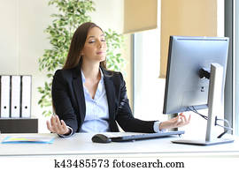 Businesswoman relaxing doing yoga at office