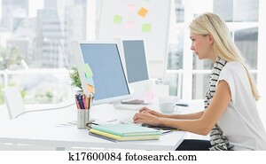 Casual young woman using computer in office