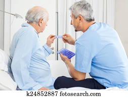 Caretaker Guiding Prescription To Senior Man