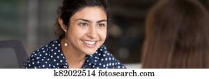 Indian girl having pleasant conversation with colleague during break Indian girl having pleasant conversation with colleague during break