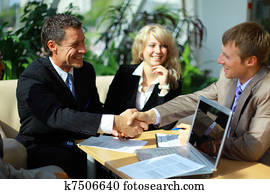 Business people shaking hands, finishing up a meeting 