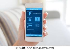 female hand holding phone with smart home on the screen