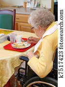 Old woman eating lunch in handicap chair