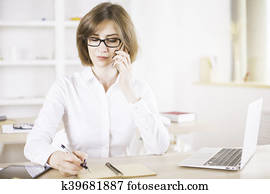 Woman on phone writing