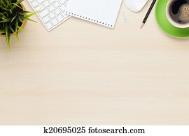 Office table with notepad, computer and coffee cup