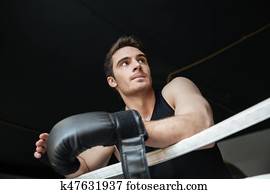 Thoughtful sportsman standing on ring Thoughtful sportsman standing on ring