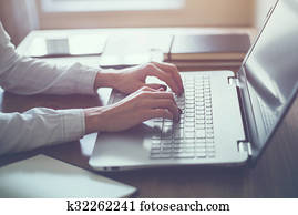 Woman working in home office hand on keyboard close up