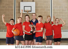 Victorious School Sports Team With Trophy In Gym