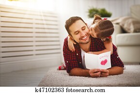 Father's day. Happy family daughter kiss dad and giving greeting card Father's day. Happy family daughter kiss dad and giving greeting card