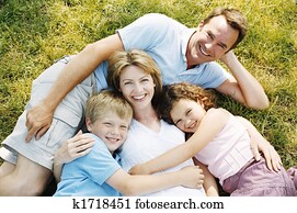 Family lying outdoors smiling Family lying outdoors smiling