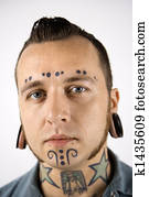 Man with tattoos and piercings.