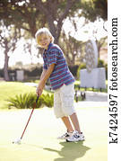 Young Boy Practising Golf On Putting On Green