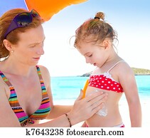 daughter and mother in beach with sunscreen daughter and mother in beach with sunscreen