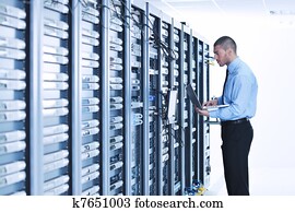 businessman with laptop in network server room businessman with laptop in network server room