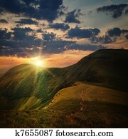 peak of the hill with pathway and mountain sunset