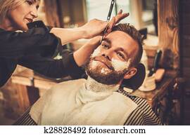 Client during beard shaving in barber shop Client during beard shaving in barber shop