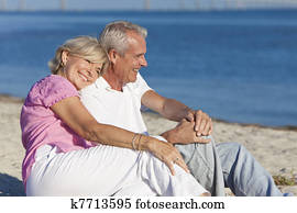 Happy Romantic Senior Couple Sitting Together on Beach