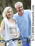 Happy Senior Man & Woman Couple Cycling Bicycles