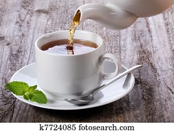 Pouring tea into cup of tea Pouring tea into cup of tea